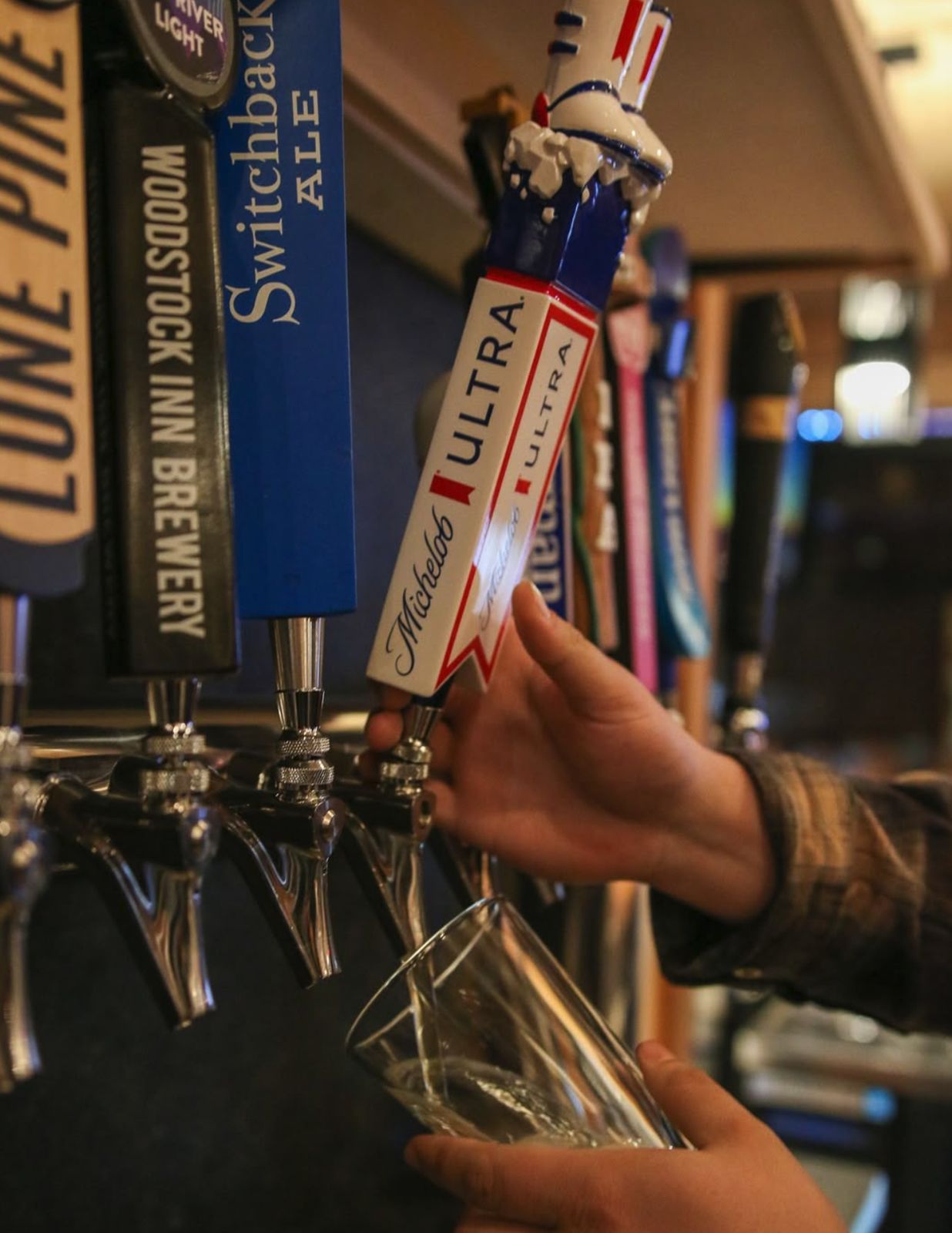 A bartender pulling a draft from the tap line